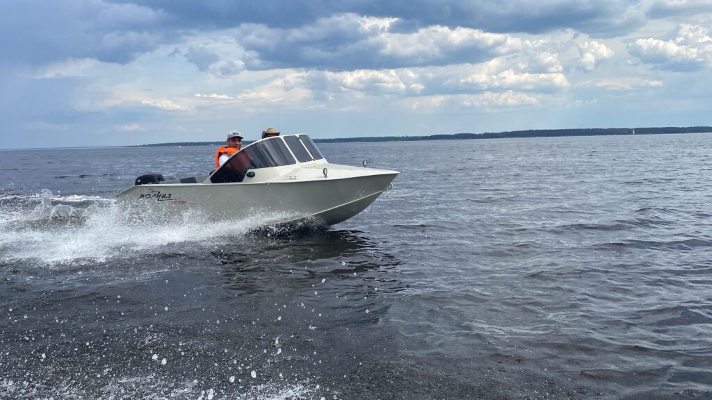 alt="Лодка Молния 400К из ПНД на воде с подвесным мотором"